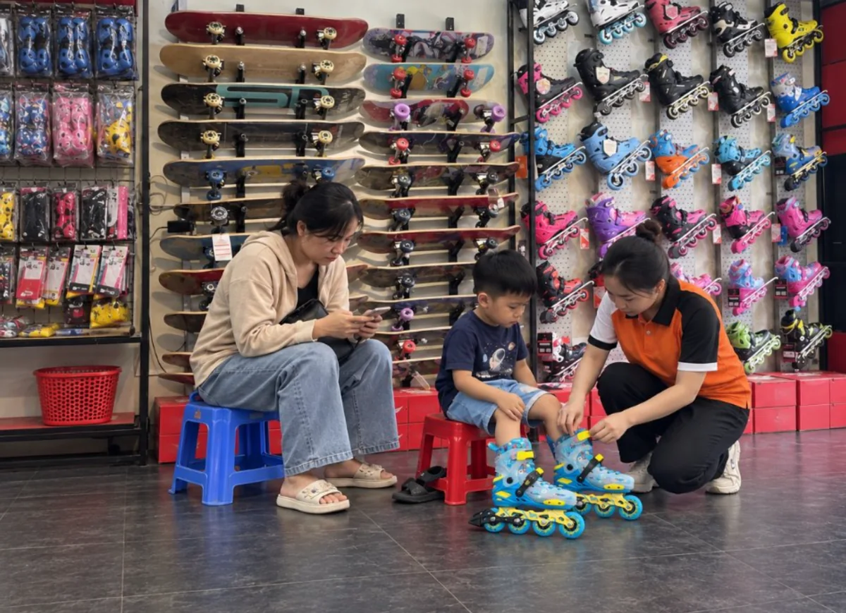 Nhân viên cài khoá giày patin trẻ em Centosy Kid Pro cho bé ngồi ghế nhựa trong cửa hàng